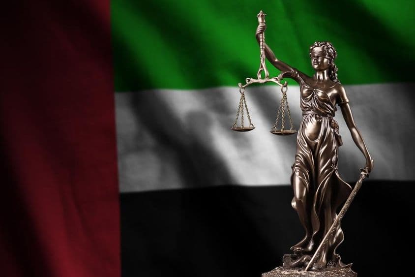 Vlajka Spojených arabských emirátov so sochou lady Justície.