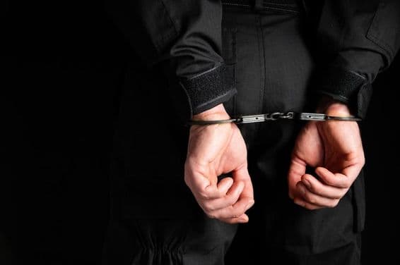 Ruky zločinca v putách.