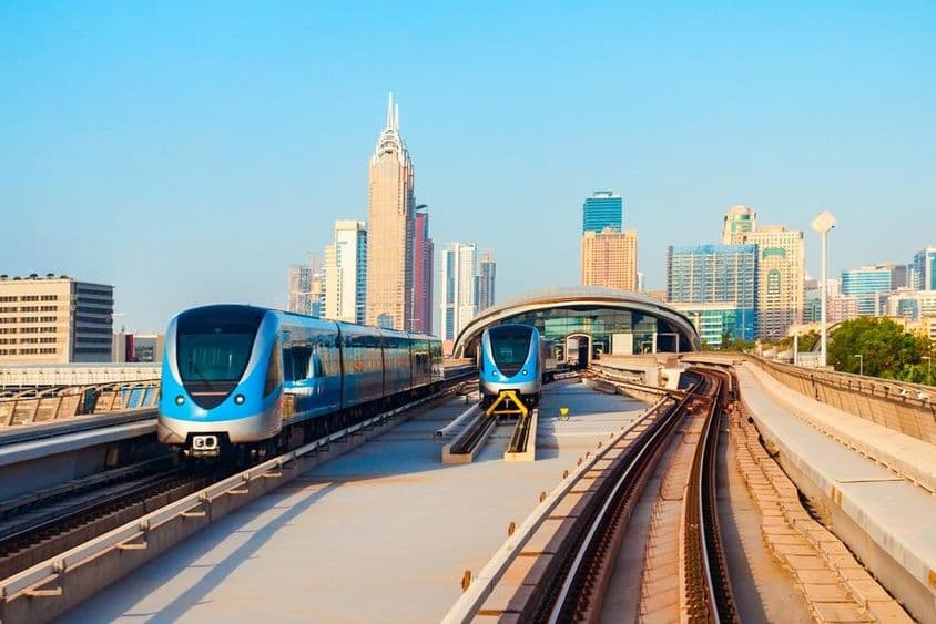 Vlaky dubajského metra a panoráma mesta Dubaj v Spojených arabských emirátoch.