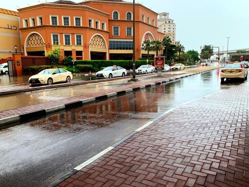 Auta jazdiace cez zaplavené ulice Dubaja v daždi.