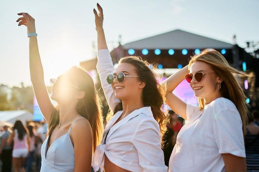 Dievčatá v letných šatách užívajúce si koncert.