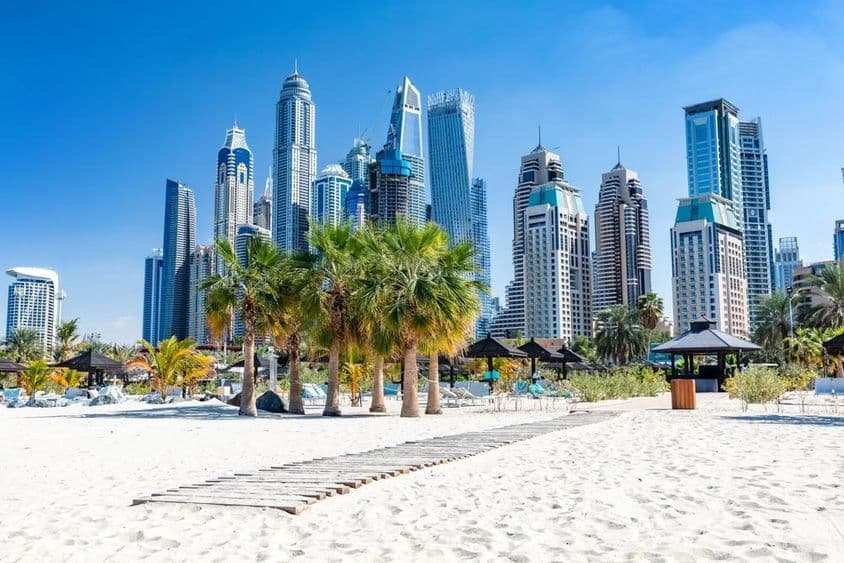 Pláž Jumeirah v Dubaji s prístavnými mrakodrapmi v Spojených arabských emirátoch.