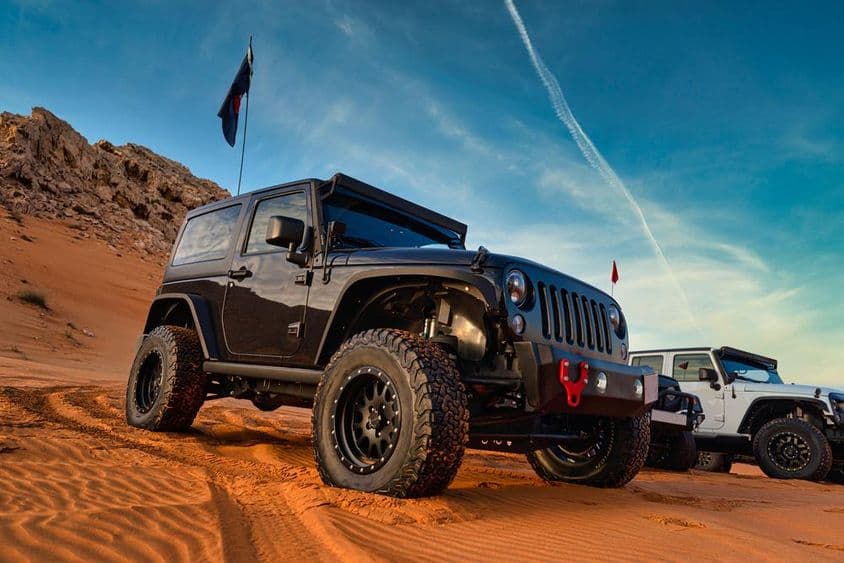 Jeep Wrangler na off-road dobrodružstve na pieskovej dune v červenej púšti Dubaja.