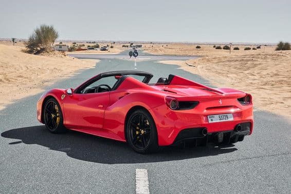 Červené Ferrari 488 na opustenej púštnej ceste v Dubaji.