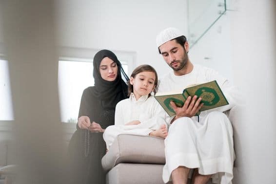 Mladí rodičia a malý chlapec čítajúci knihu.