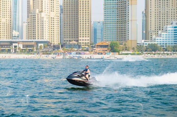 Muž na vodnom skútre v Dubai Marina Bay.