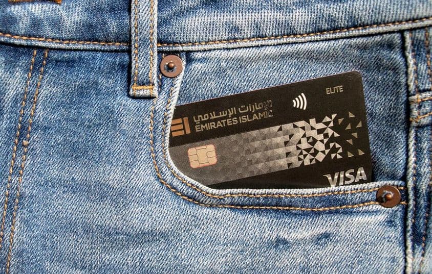 Plastová Visa kreditná karta Islamskej banky emirátov vo vrecku džínsov.