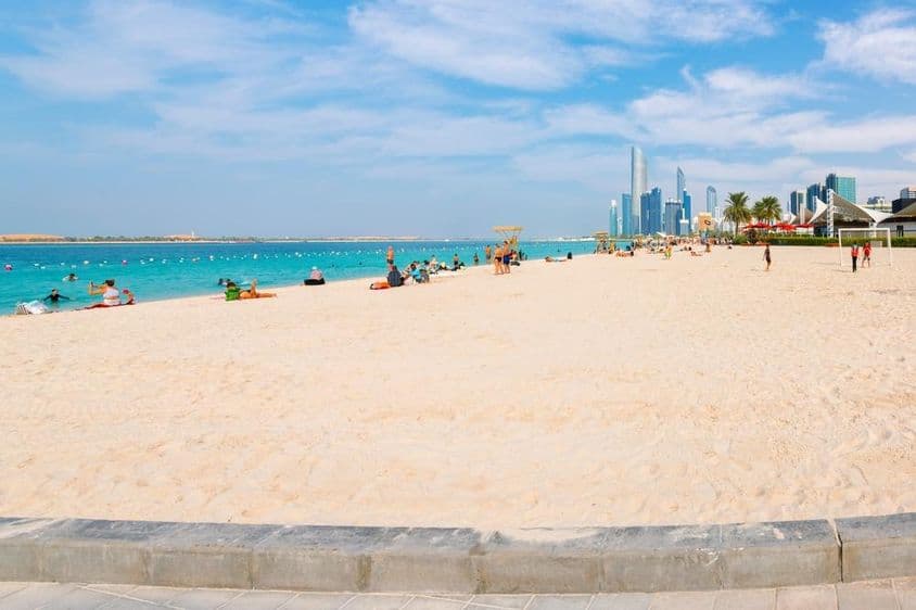 Široká, piesočná pláž Corniche pri Arabskom zálive.
