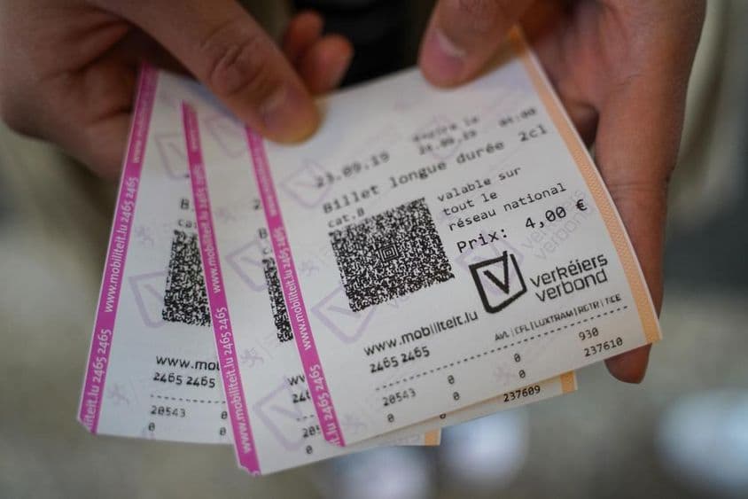 Mladý muž držiaci vstupenky v ruke.