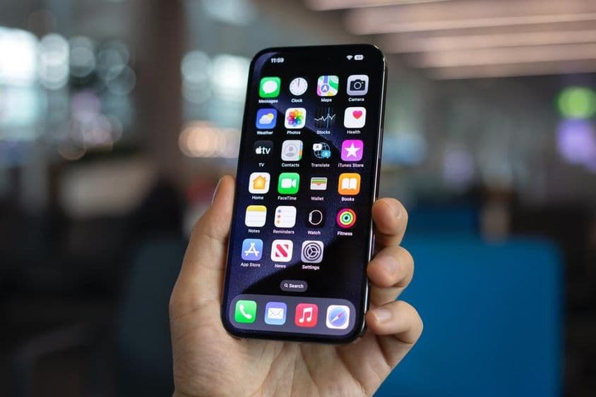 Muž drží iPhone 15 Pro Max.
