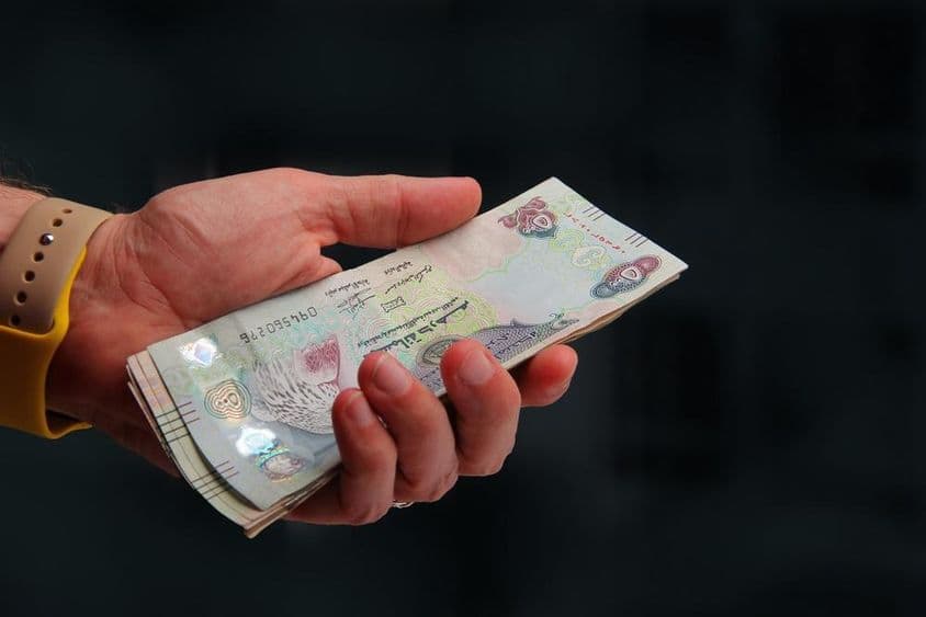 Spojené arabské emiráty, dubajský dirham v ruke človeka.