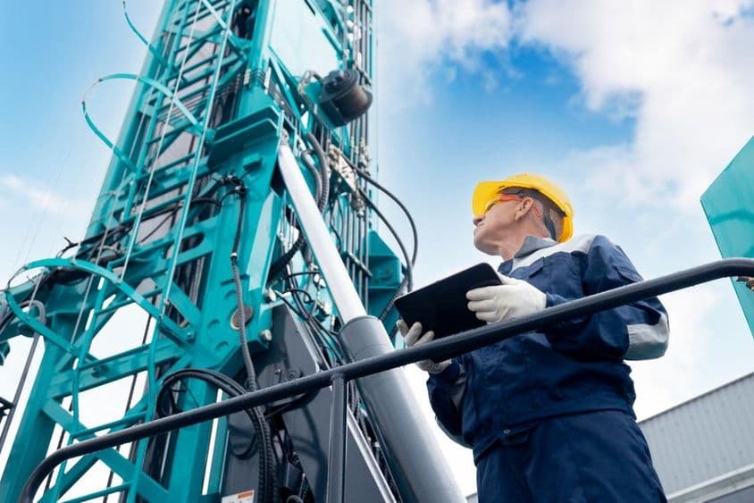 Operátor priemyslu používajúci digitálny tablet na ovládanie vŕtacej platformy.