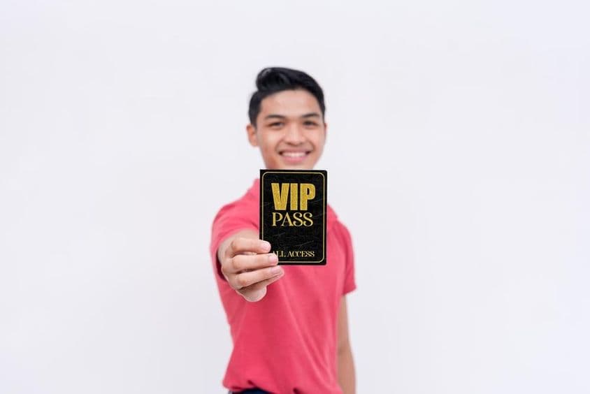 Šťastný muž držiaci VIP lístok alebo preukaz.