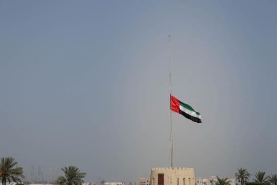 Vlajka Spojených arabských emirátov spustená na pol žrde v Sharjahu.