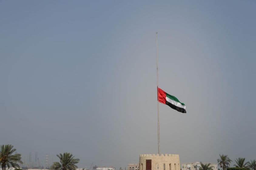 Vlajka Spojených arabských emirátov spustená na pol žrde v Sharjahu.