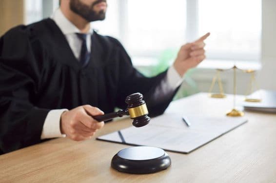 Sudca klopá a súd vynáša rozsudok v súdnej sieni.