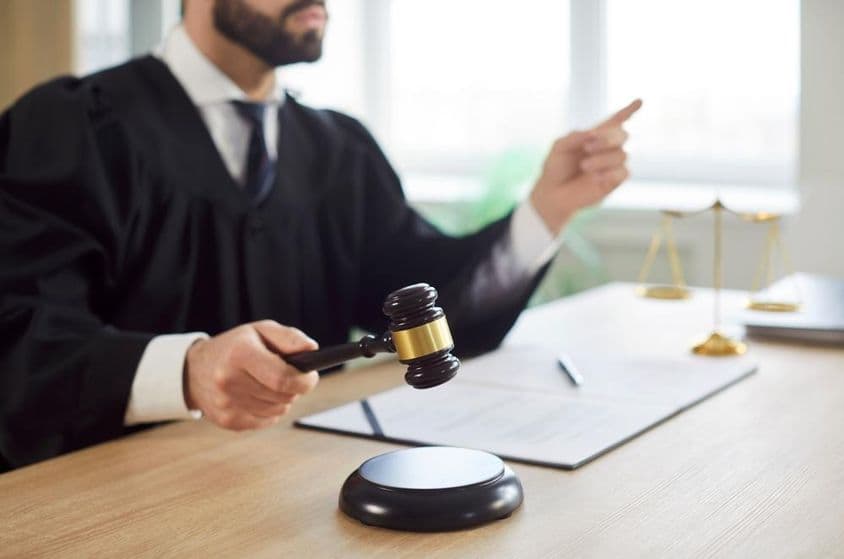 Sudca klopá a súd vynáša rozsudok v súdnej sieni.