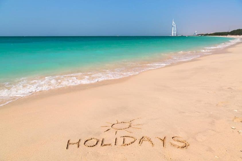 Dovolenková značka na pláži s tyrkysovou vodou.