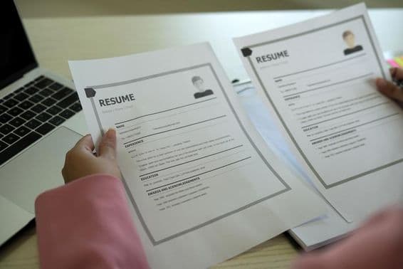 Mladá ázijská personalistka číta životopis.