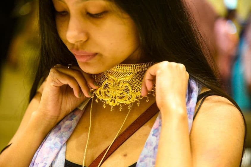 Žena skúša šperky na Dhanteras.