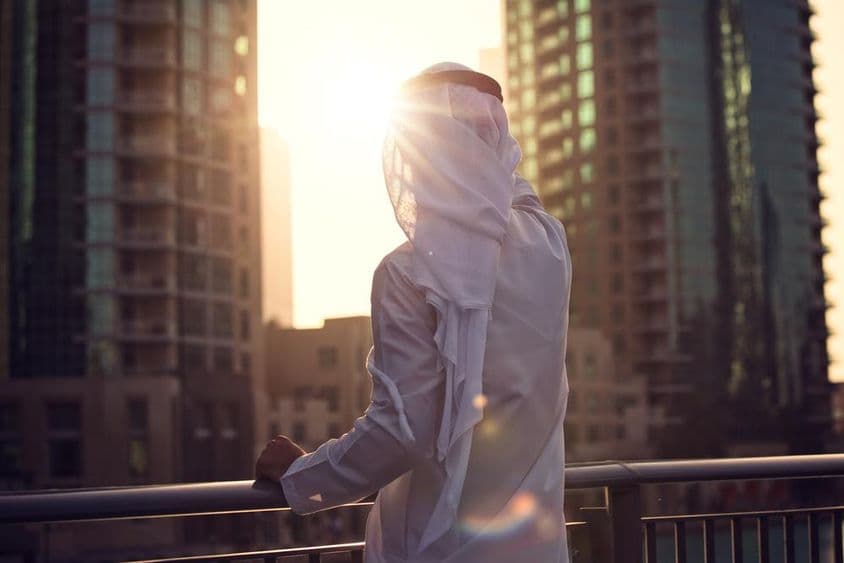 Arabský muž sledujúci západ slnka v Dubaji.