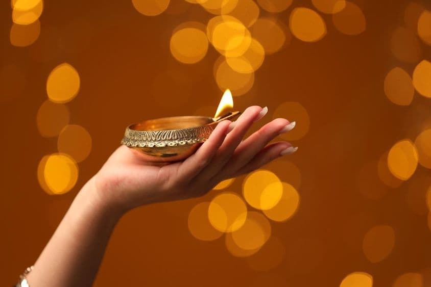 Žena držiaca zapálenú Diwali lampu