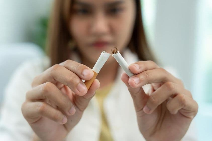 Žiadne fajčenie, žena láme cigaretu napoly.