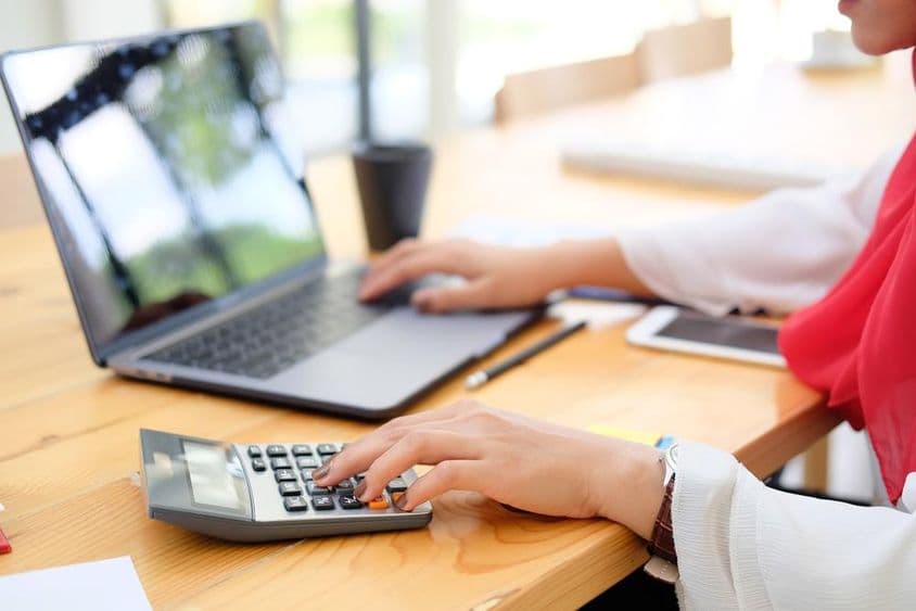 Žena pracujúca s financiami a vypočítavajúca daň.