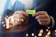 Podnikateľ ukazujúci dokument s nápisom 'darovanie'.