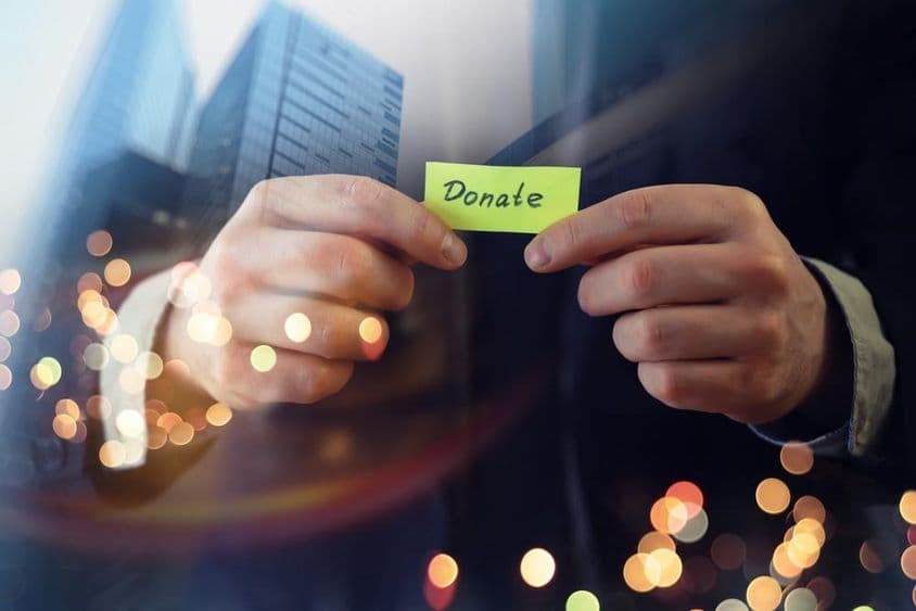 Podnikateľ ukazujúci dokument s nápisom 'darovanie'.