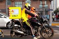 Motocyklový kuriér doručujúci na ulici v Dubaji.