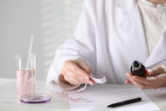 Luxusný parfum na biele drevenej stole v laboratóriu.