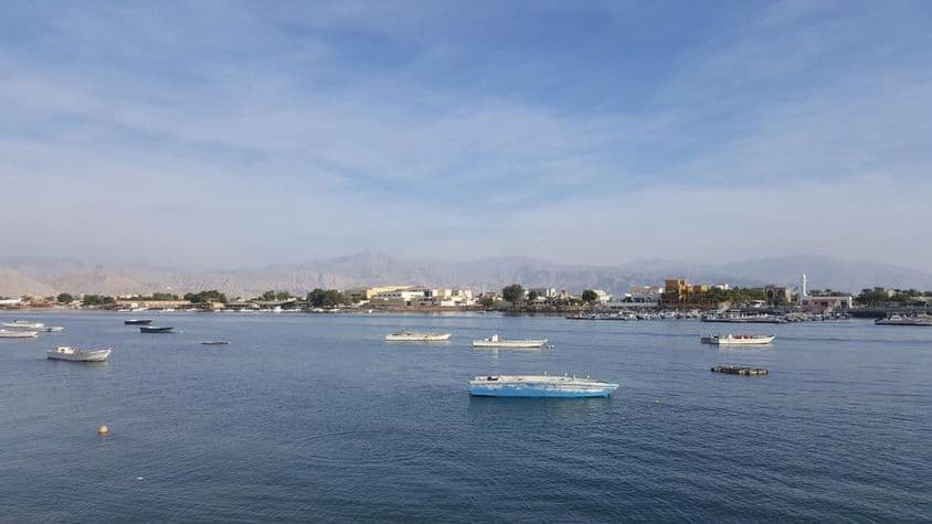 Záliv Ras Al Khaimah s modrým morom a oblačnou oblohou.