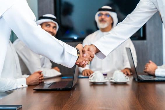 Biznismeni z Blízkeho východu v emirátskej kandure pracujúci v zasadacej miestnosti v Dubaji.
