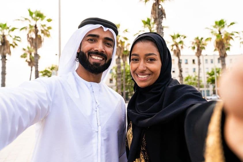 Tradičný arabský pár v emirátskom odeve na schôdzke vonku.