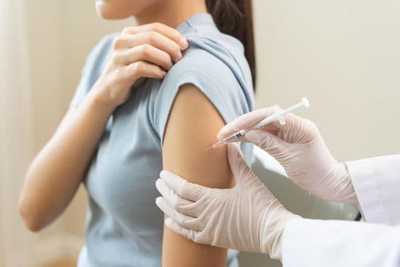 Lekár podáva vakcínu pacientovi na klinike.