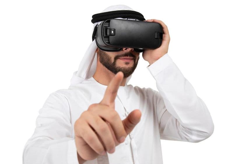 Arab muž gestikulujúci s VR headsetom.