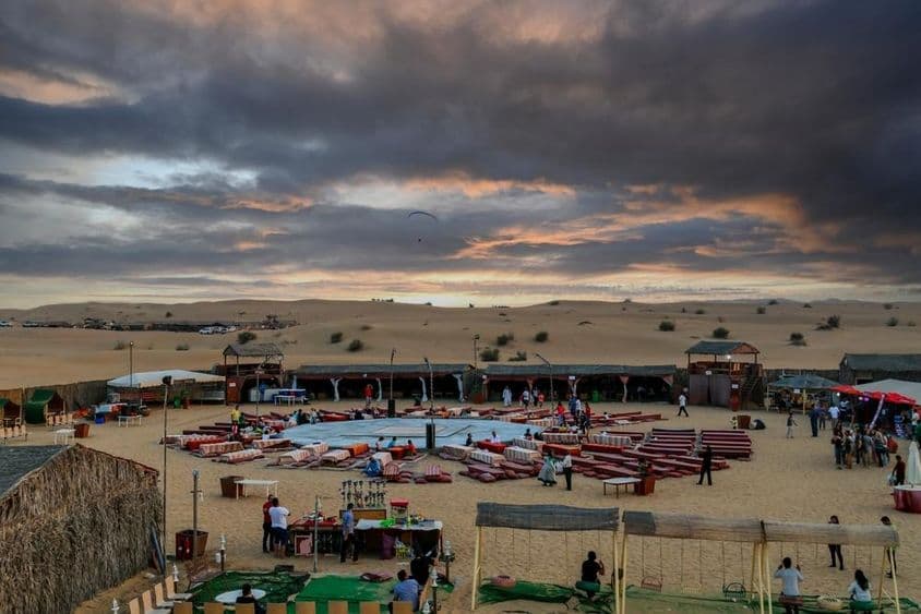 Západ slnka nad beduínskym táborom po tradičných púštnych safari v Dubaji.
