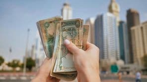 Dievča držiace menu SAE s dubajskými mrakodrapmi v pozadí.