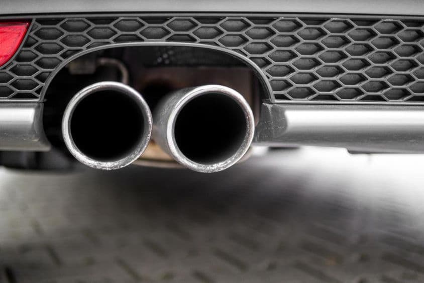 Strieborná výfuková rúra automobilu.