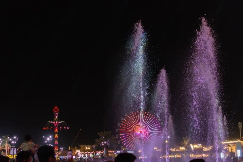 Farebná nočná scéna na Sheikh Zayed Festivale s vodnými fontánami.