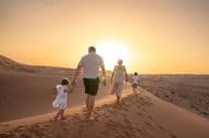 Rodina si užíva západ slnka v púšti.