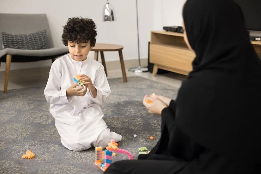 Mladá arabská žena učiaca s kreatívnymi hračkami v moslimskom domove.