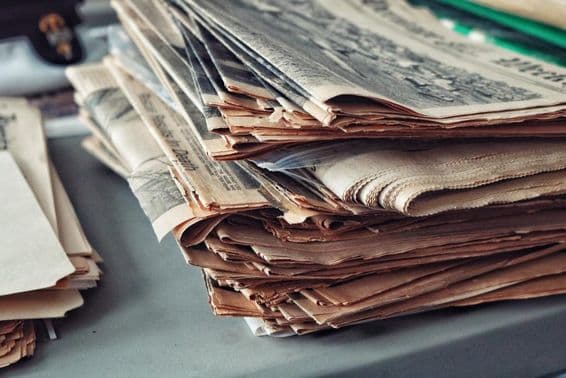 Staré noviny naskladané s pavučinami.