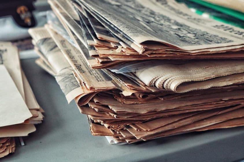 Staré noviny naskladané s pavučinami.