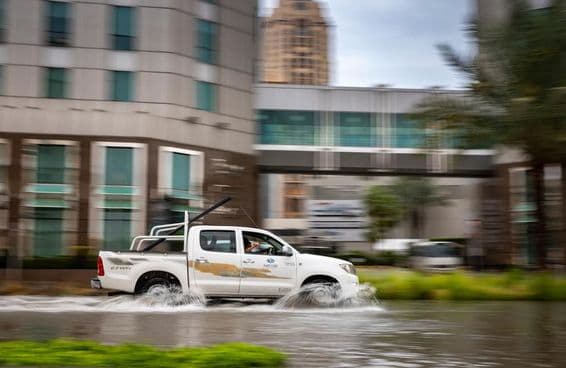 Auto jazdiace cez zaplavenú ulicu v Dubaji.