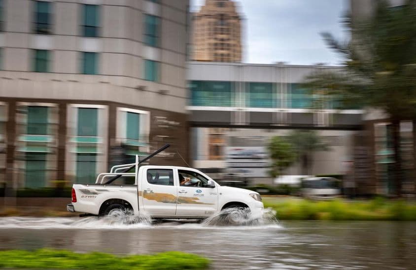 Auto jazdiace cez zaplavenú ulicu v Dubaji.