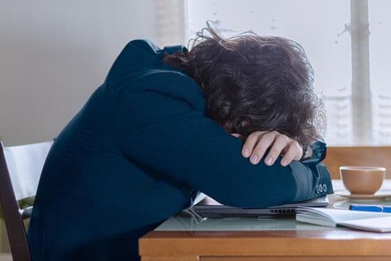 Osoba odpočívajúca na svojom laptopu v práci v pondelok.