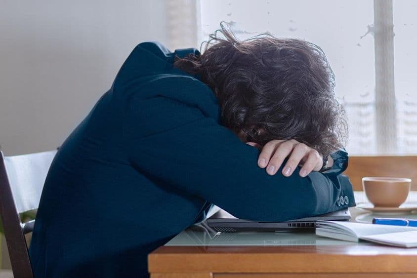 Osoba odpočívajúca na svojom laptopu v práci v pondelok.