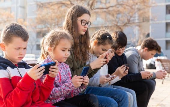 Deti komunikujú prostredníctvom správ na smartfóne.